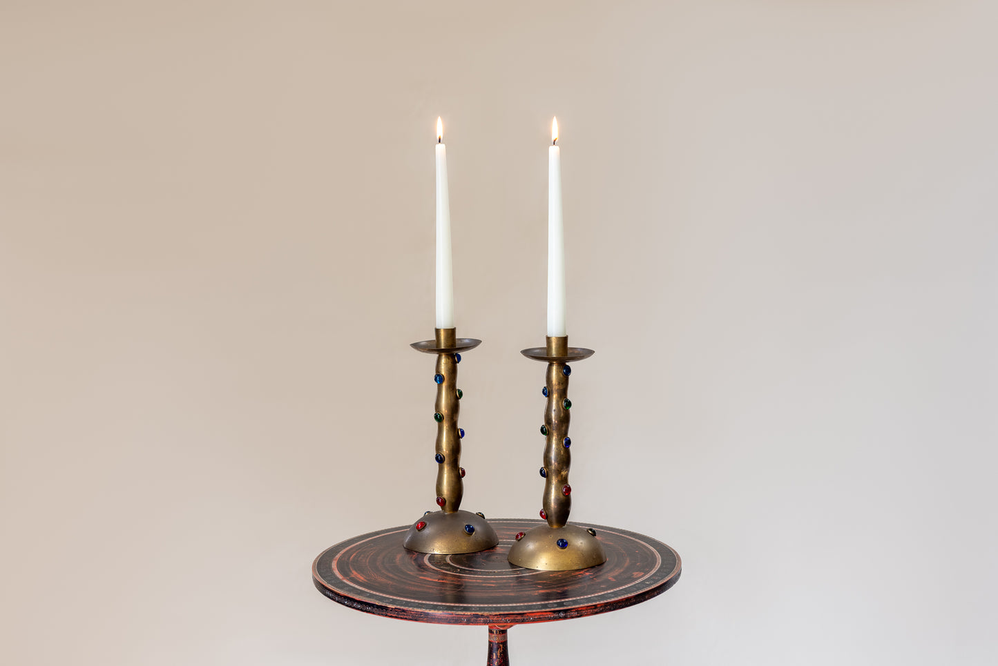 A Pair of Cabochon Mounted Brass Candlesticks