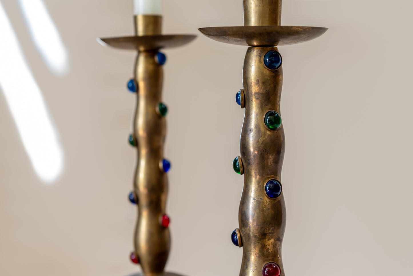 A Pair of Cabochon Mounted Brass Candlesticks